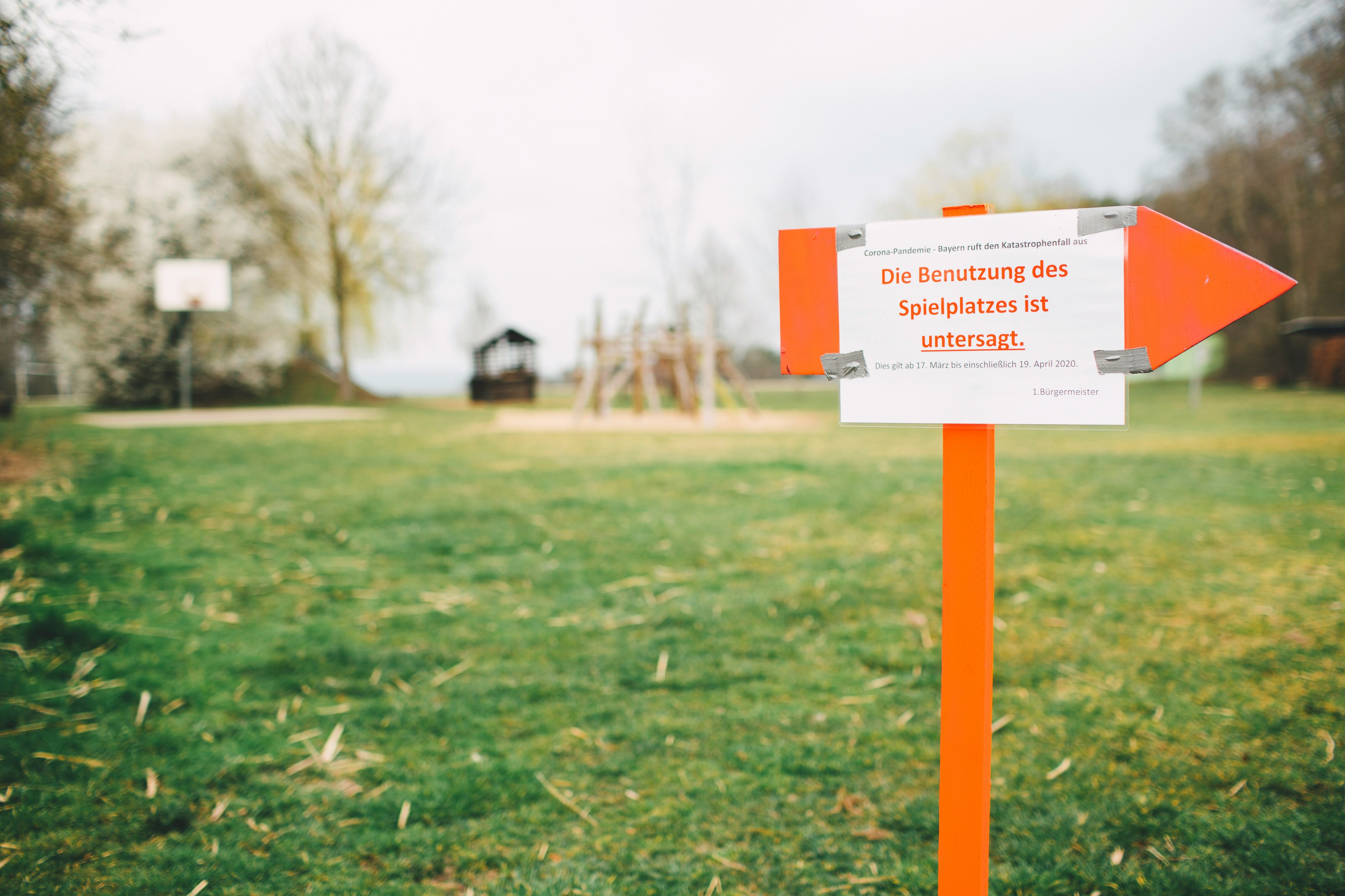 orange and white road sign on green grass field during daytime